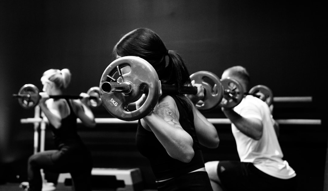 Athletes performing compound exercises barbell training in gym