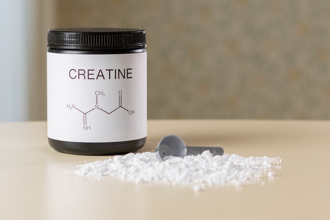 Creatine monohydrate powder and supplement scoop for strength training