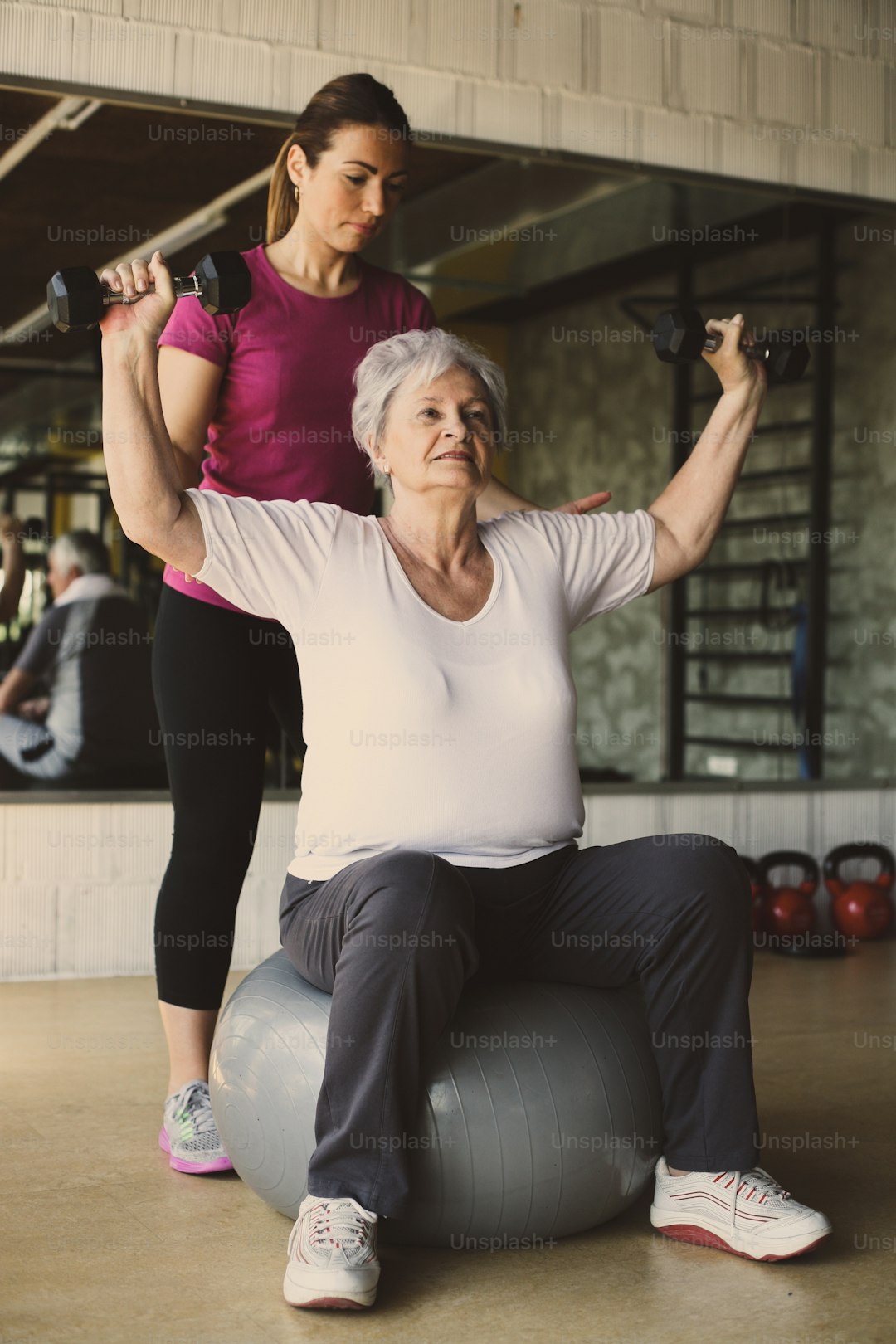 Senior woman doing strength training with personal trainer