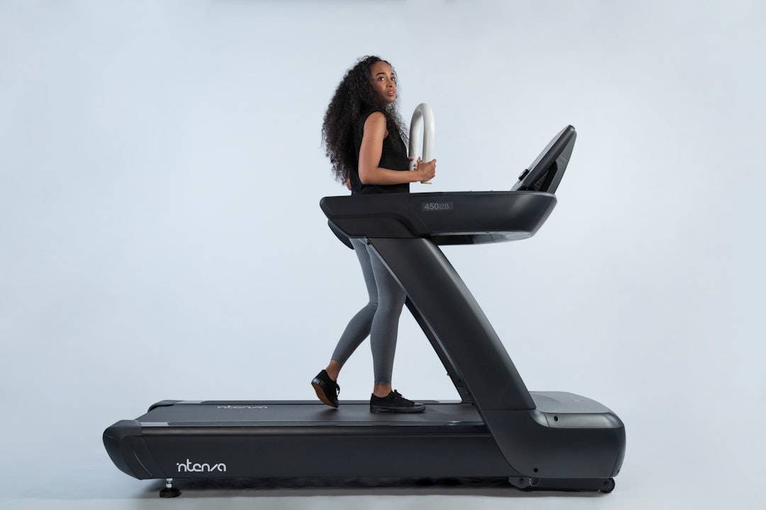 Person running on treadmill with heart rate monitor for cardio training